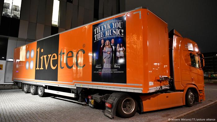 A large truck outside the concert venue with a poster that reads, Thank You For Your Music, referring to an ABBA song. 