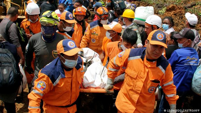Foto de personal de emergencia que lleva un cuerpo recuperado tras deslave en Mallama.