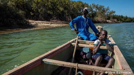 A man and a boy in a wooden boat off the coast of Saint-Louis, Senegal