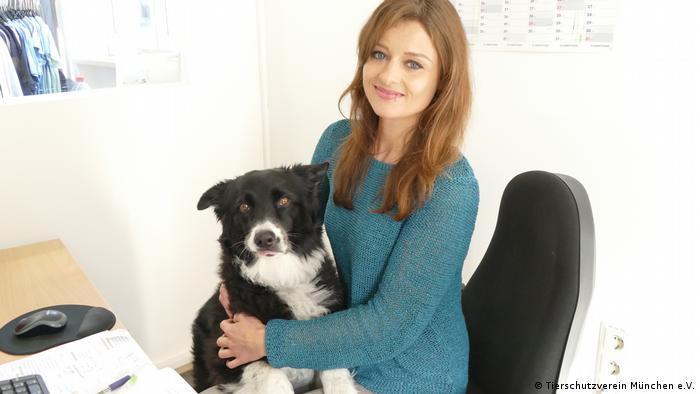 Kristina Berchtold in her office holding a dog on her lap