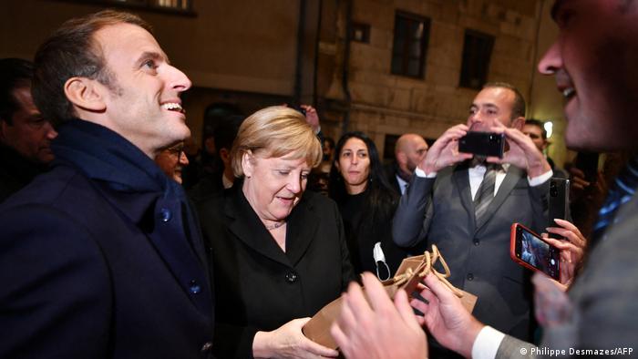 Macron und Merkel werden mit einer Flasche Wein in Beaune begrüßt