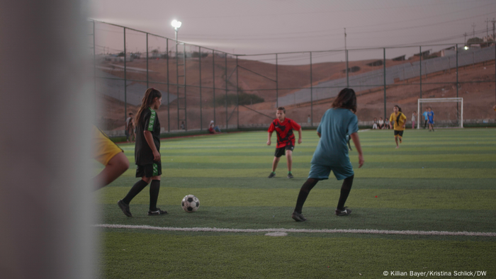 Children playing soccer in the evening light