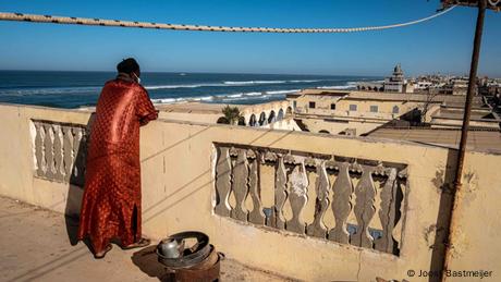 A man looking over the rooftops of Guet Ndar, a neighborhood on Langue de Barbarie 