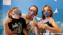 Una familia: madre, hijo e hija con mascarillas contra el coronavirus.