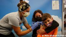 Five year-old Renan Rojas sits on his mom, Daniela Cantano's lap, as he receives the Pfizer-BioNTech coronavirus vaccine from registered nurse Jillian at Rady's Children's hospital vaccination clinic in San Diego, California, U.S., November 3, 2021. REUTERS/Mike Blake