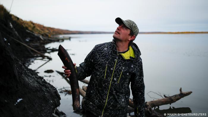 Nikita Zemov, director of the Ice Age park, with a huge bone in Yakutia.  Photograph: Maxim Shemetov/Reuters 