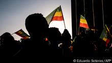 People hold Ethiopian flags during a memorial service for the victims of the Tigray conflict