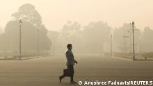 FILE PHOTO: A man walks along a road on a smoggy morning in New Delhi, India, December 23, 2020. REUTERS/Anushree Fadnavis/File Photo