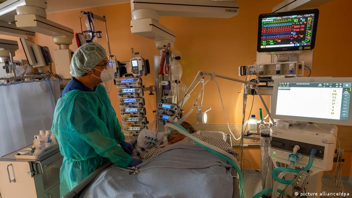 Doctor standing at the bed of a patient in intensive care