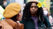 Climate activist Dominique Palmer (R) joins campaigners at a demonstration demanding that 'big finance' defunds fossil fuels, outside the headquarters of Standard Chartered bank in the City of London on October 29, 2021, ahead of the COP26 UN Climate Change Conference to be held in Glasgow, Scotland from October 31. - From Bangladesh to Britain to Nigeria, many young campaigners on the frontlines of the global fight for climate justice now face a new problem: the impact the crisis is having on their mental health. (Photo by Tolga Akmen / AFP)