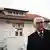 a portrait of Steinmeier in a black coat on a visit to the island