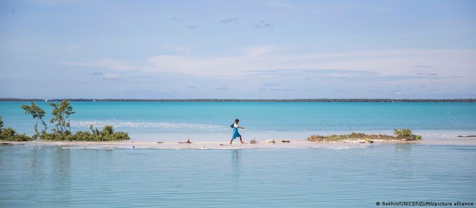 Para menino da ilha Kiribati, no Pacífico, caminho da escola agora passa pelo mar