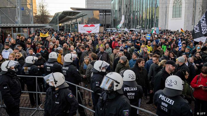 Un policier se tient devant des manifestants lors d'une manifestation anti-COVID à Leipzig