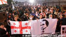 Georgian opposition supporters of former president Mikheil Saakashvili hold national flags and posters with his portraits during a rally in front of the prison where the former president is being held, in Rustavi, about 20 km from the capital Tbilisi, Georgia, Saturday, Nov. 6, 2021. Saakashvili was detained in Tbilisi on Saturday, Oct. 1, 2021. Doctors say former President Mikheil Saakashvili is very weak as he nears 40 days on hunger strike. He started the hunger strike after being arrested at the beginning of October when he returned to Georgia. Saakashvili, who left Georgia in 2014 and became a Ukrainian citizen, faces several charges in Georgia and earlier was sentenced in absentia to up to six years in prison. (AP Photo/Shakh Aivazov)