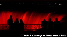 People overlook the illuminated waterfall during the annual Winter Festival of Lights in Niagara Falls, Ontario, Sunday, Dec. 6, 2020. (Nathan Denette/The Canadian Press via AP)