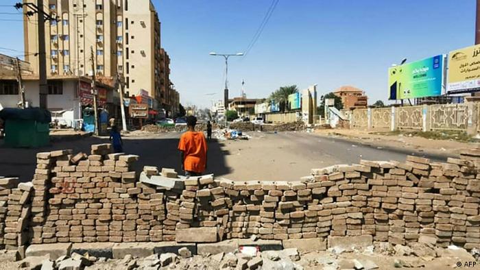 Auf einer Straße in Khartum ist eine Mauer aus Steinen als Barrikade errichtet
