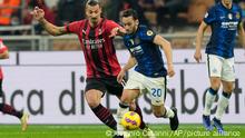 AC Milan's Zlatan Ibrahimovic, left, and Inter Milan's Hakan Calhanoglu vie for the ball during the Serie A soccer match between AC Milan and Inter Milan at the San Siro stadium, in Milan, Italy, Sunday, Nov. 7, 2021. (AP Photo/Antonio Calanni)