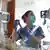 Eine Medizinerin betreut einen beatmungspflichtigen Patienten auf der Intensivstation in einer Klinik