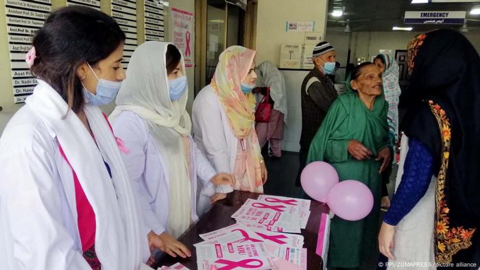 Young Pakistani women with pink pamphlets and balloons