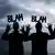 Tres activistas levantan las palmas de las manos vestidos con traje de operario y ataviados cascos de obra en los que se lee un cartel "Bla, bla, bla".