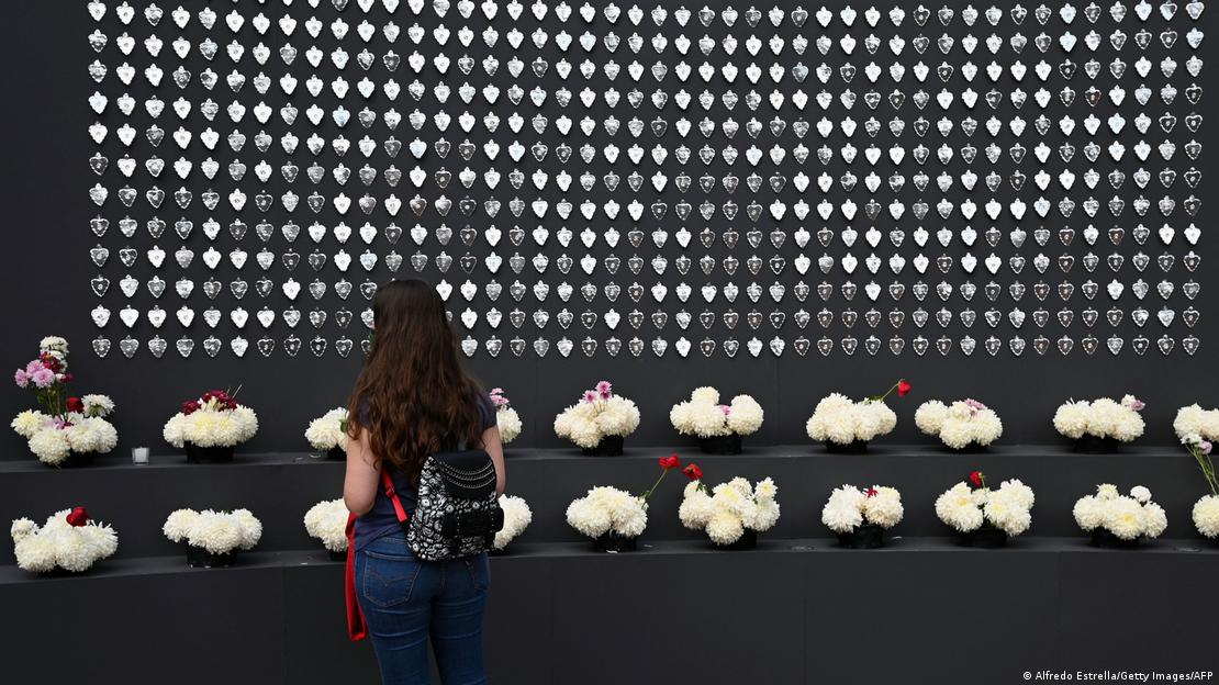 Una mujer de espaldas observa un muro con homenajes a las personas fallecidas por COVID-19 en Ciudad de México. Una mujer de espaldas observa un muro con homenajes a las personas fallecidas por COVID-19 en Ciudad de México.