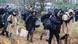 Migrants carry their belongings next to the Poland-Belarus border fence Migrants carry their belongings next to the Poland-Belarus border fence