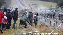 Migrants gather near a barbed wire fence in an attempt to cross the border with Poland in the Grodno region, Belarus November 8, 2021. Leonid Scheglov/BelTA/Handout via REUTERS ATTENTION EDITORS - THIS IMAGE HAS BEEN SUPPLIED BY A THIRD PARTY. NO RESALES. NO ARCHIVE. MANDATORY CREDIT.