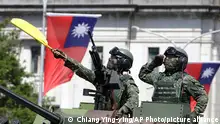 FILE - In this Oct. 10, 2021, file photo, Taiwanese soldiers salute during National Day celebrations in front of the Presidential Building in Taipei, Taiwan. After sending a record number of military aircraft to harass Taiwan over China’s National Day holiday weekend, Beijing has toned down the sabre rattling but tensions remain high, with the rhetoric and reasoning behind the exercises unchanged. (AP Photo/Chiang Ying-ying, File)
