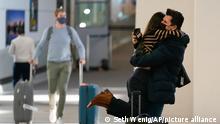 Natalia Abrahao is lifted up by her fiancé Mark Ogertsehnig as they greet one another at Newark Liberty International Airport in Newark, N.J., Monday, Nov. 8, 2021. Pandemic travel restrictions have made their recent meetings difficult and infrequent. The U.S. lifted restrictions Monday on travel from a long list of countries including Mexico, Canada and most of Europe, setting the stage for emotional reunions nearly two years in the making and providing a boost for the airline and tourism industries decimated by the pandemic. (AP Photo/Seth Wenig)
