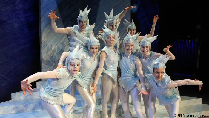 The Snow Queen with performers dressed in silver costumes and head decorations.