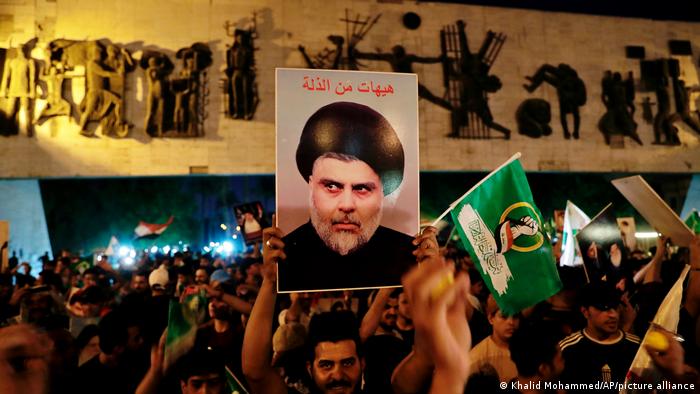 Followers of Shiite cleric Muqtada al-Sadr celebrate holding his posters, after the announcement of the results of the parliamentary elections in Baghdad.