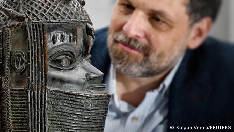 Museum director Neil Curtis seen looking at a Benin bronze