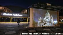 A projection of the former synagogue is seen at its historic place in Dortmund, Germany, Tuesday, Nov. 9, 2021, to mark the 83rd anniversary of the anti-Jewish pogrom that was labeled Kristallnacht — the Night of Broken Glass — when Nazis among them many ordinary Germans, terrorized Jews throughout Germany and Austria. Cities all over Germany project the digital reconstructed synagoges at the places where they were destroyed by the Nazis. (AP Photo/Martin Meissner)