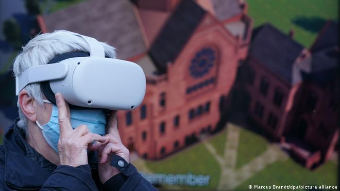 a member of the Auschwitz committee wearing a VR headset to experience a 3D version of the Bornplatz synagogue