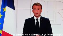 France's President Emmanuel Macron appears on a TV screen as he addresses to the nation on Covid-19 and reforms in Paris on November 9, 2021. - For the ninth time since the beginning of the Covid-19 crisis, Emmanuel Macron solemnly addresses the French to boost the vaccine recall in the face of the rebound of the epidemic, to boast of his record and to evoke the priorities of the end of the five-year term. (Photo by Christophe ARCHAMBAULT / AFP) (Photo by CHRISTOPHE ARCHAMBAULT/AFP via Getty Images)