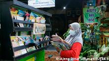 Founder of the waste library (Limbah Pustaka), Raden Roro Hendarti, 48, arranges books on a three-wheeler vehicle at the library in Muntang village, Purbalingga, Central Java province, Indonesia November 2, 2021. Picture taken November 2, 2021. REUTERS/Ajeng Dinar Ulfiana