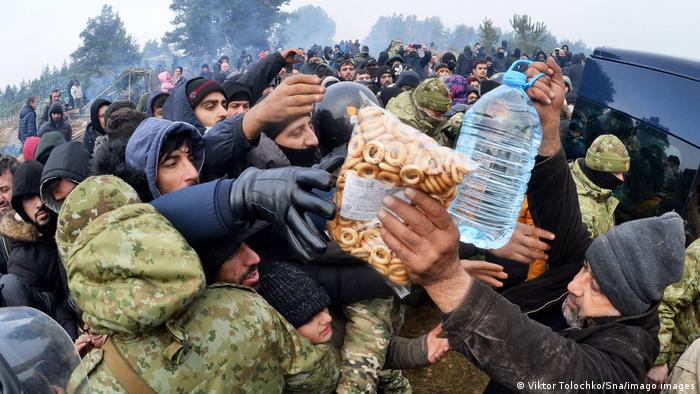 منظمات إنسانية توزع مواد غذائية على المهاجرين العالقين في المنطقة الحدودية بين بولندا وبيلاروسيا.