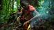 A man lights a campfire on the forest floor