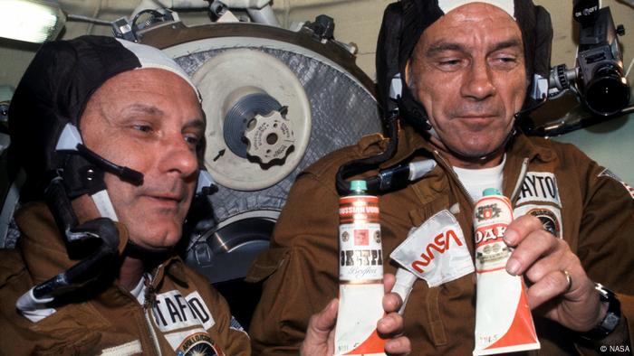 Two astronauts Thomas Stafford und Deke Slayton hold tubes of vodka