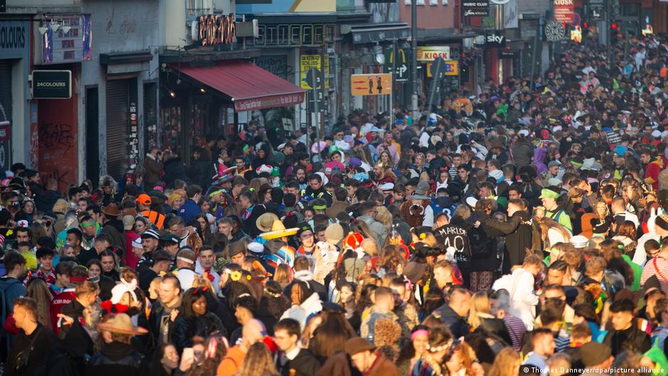 Menschenmassen drängen sich an Karneval in einer Straße. 