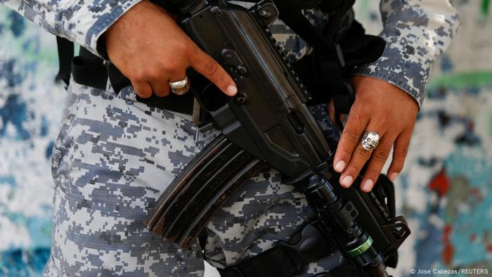 Foto simbólica de un agente de la Policía que sostiene su arma en El Salvador