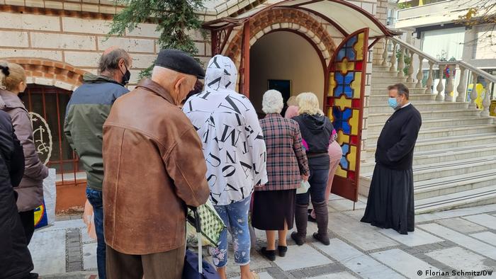 Older people queue in front of a church in Thessaloniki