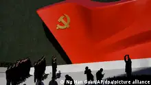 Mitglieder der Kommunistischen Partei Chinas stehen für Fotos mit einer Skulptur der Parteiflagge vor dem Museum der Kommunistischen Partei Chinas. Das Zentralkomitee der Kommunistischen Partei Chinas hat sich in einer «historischen Resolution» zum Abschluss ihres viertägigen Plenums hinter eine anhaltende Führungsrolle von Staats- und Parteichef Xi Jinping gestellt. +++ dpa-Bildfunk +++