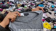 A woman searches for used clothes amid tons discarded in the Atacama desert, in Alto Hospicio, Iquique, Chile, on September 26, 2021. - EcoFibra, Ecocitex and Sembra are circular economy projects that have textile waste as their raw material. The textile industry in Chile will be included in the law of Extended Responsibility of the Producer (REP), forcing clothes and textiles importers take charge of the waste they generate. (Photo by MARTIN BERNETTI / AFP) (Photo by MARTIN BERNETTI/AFP via Getty Images)