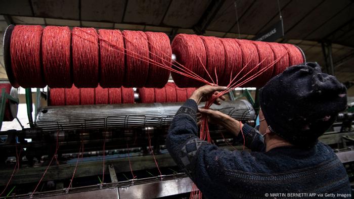 A woman working at a yarn machine