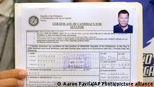 A representative of Philippine President Rodrigo Duterte holds his Certificate of Candidacy for Senator at the Commission on Elections in Manila, Philippines,Monday, Nov. 15, 2021. Duterte filed his candidacy Monday for a Senate seat in next year's elections, walking back on his announcement that he would retire from politics when his term ends and prompting human rights activists to press allegations that he would do anything to cling to power to evade accountability for his deadly anti-drugs crackdown. (AP Photo/Aaron Favila)