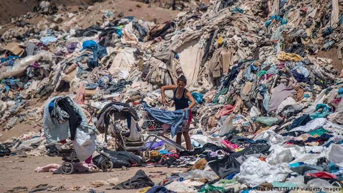 A woman at a garbage dump of clothes