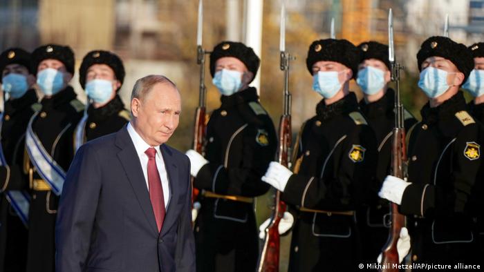 Foto de Vladimir Putin frente a soldados que usan mascarillas en Rusia.