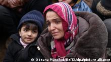 A woman and her child warm themselves at a fire as other migrants gather at the Belarus-Poland border near Grodno, Belarus, Sunday, Nov. 14, 2021.Poland's prime minister says Poland, Lithuania and Latvia are considering asking NATO for emergency talks as they struggle to manage a tense standoff on their borders with Belarus. The EU nations say Belarus is orchestrating a migrant crisis on their borders in retaliation for EU sanctions on Belarus for cracking down on democracy protesters. (Oksana Manchuk/BelTA pool photo via AP)