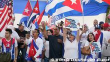 Demonstrators wave flags in support of the protests in Cuba, Monday, Nov. 15, 2021, in front of the Versailles Cuban Restaurant in the Little Havana neighborhood of Miami. (AP Photo/Wilfredo Lee)